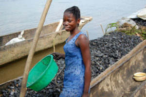 A woman unloading charcoal from river boats in Africa. Photo by Jolien Schure for Center for International Forestry Research (CIFOR).