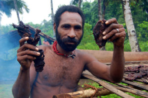 A man holds up bushmeat, Papua, Indonesia. Photo: Agus Andrianto/CIFOR  